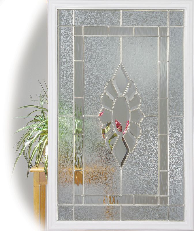 Decorative frosted glass door panel with floral etched design and gray border, beside a potted plant