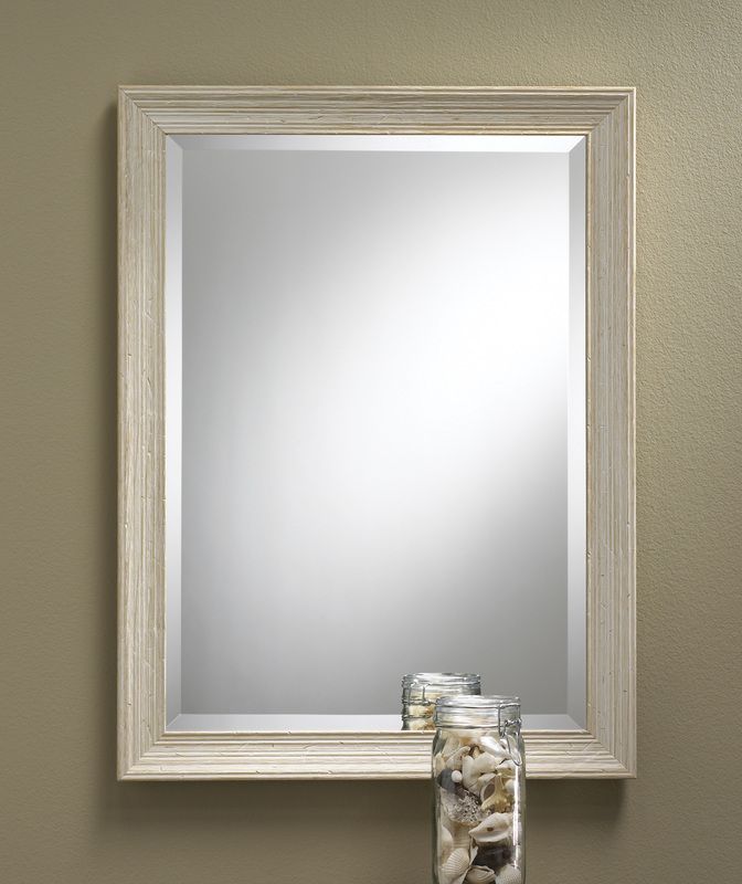 Beige-framed wall mirror with a few small glass jars at the bottom edge
