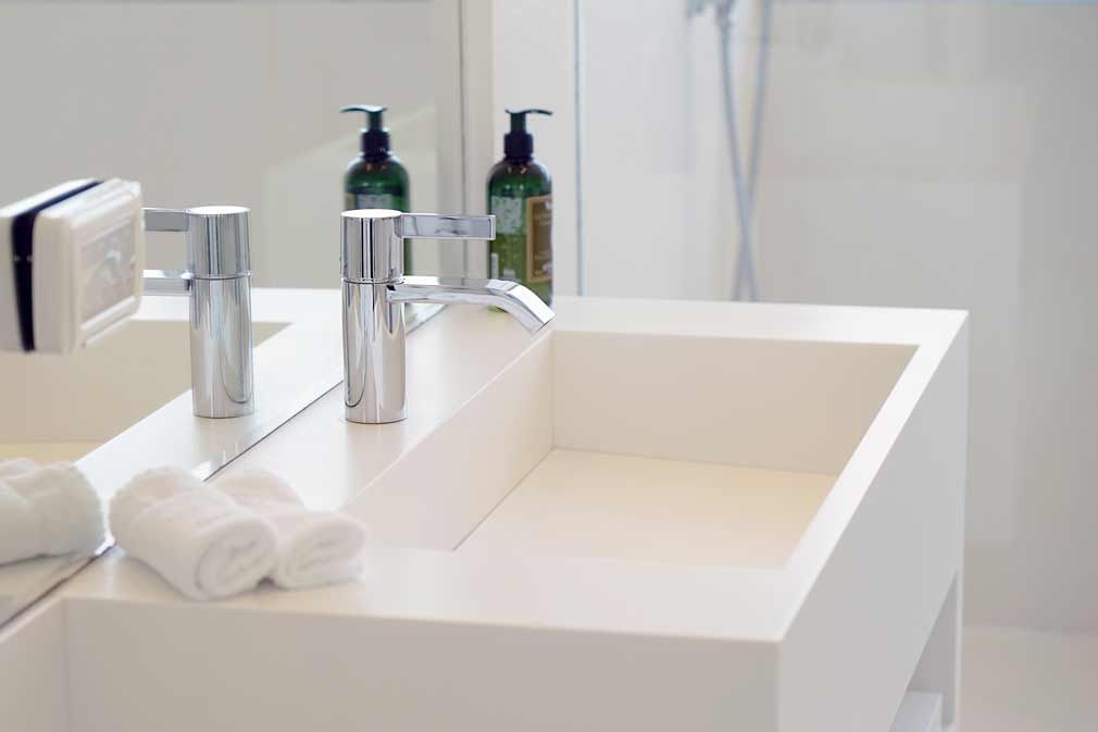 A bathroom sink with a mirror and two towels on it