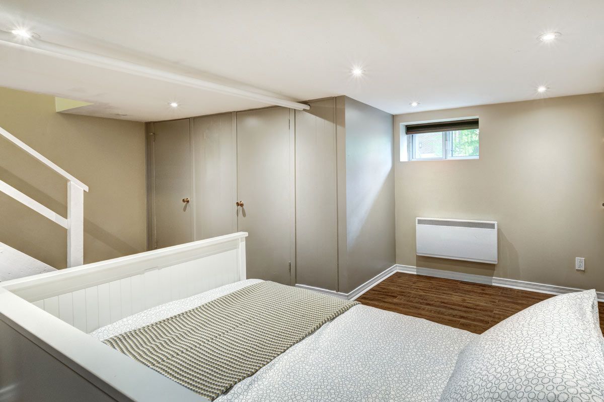 A bedroom with a bed , stairs and a window