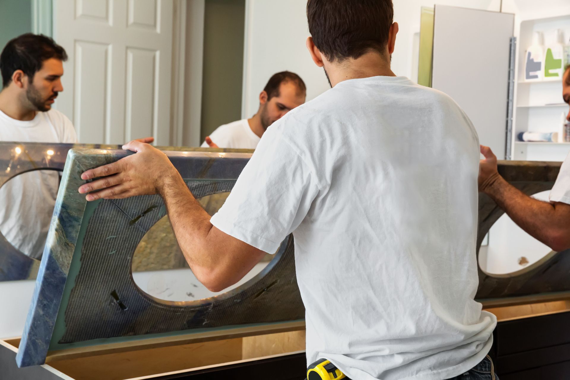 Two men in white shirts installing a new countertop, showcasing bathroom remodeling services.