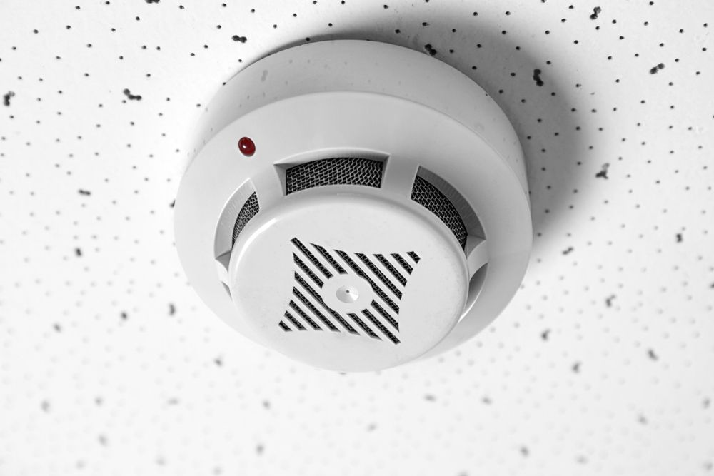 White Fire Alarm Mounted on a Textured Ceiling — EBS NQ Electronic Building Systems in Kirwan, QLD