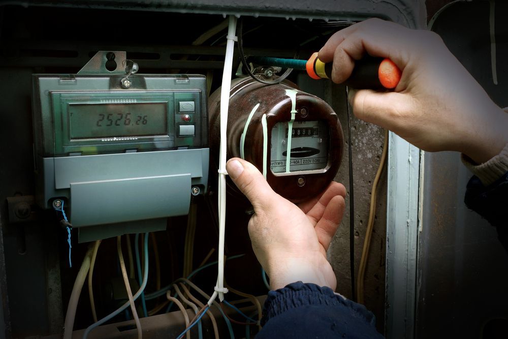 Person Using a Screwdriver on an Electrical Meter — EBS NQ Electronic Building Systems in Kirwan, QLD