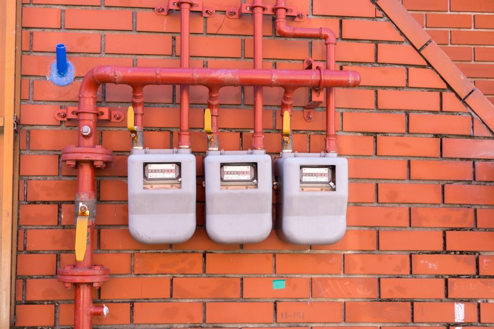 Three Gas Meters Mounted on a Red Brick Wall — EBS NQ Electronic Building Systems in Kirwan, QLD