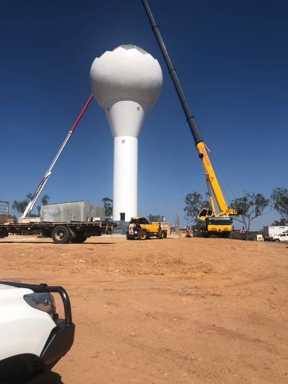 A Tall White Water Tower Being Constructed With Cranes on a Sunny — EBS NQ Electronic Building Systems in Kirwan, QLD