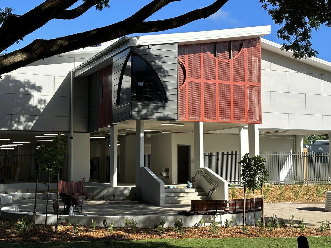 Modern Building With Open-air Entrance, Grey and Orange Facade — EBS NQ Electronic Building Systems in Kirwan, QLD