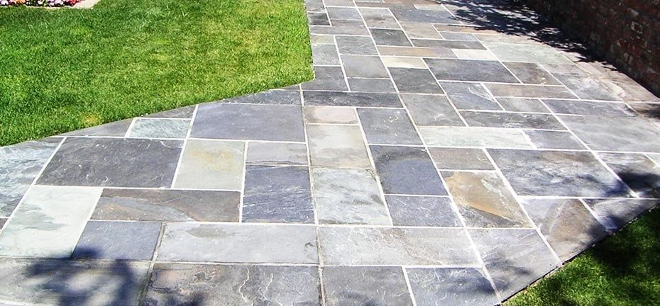 Stone patio next to a green lawn.