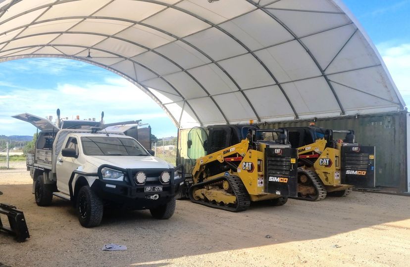 Heavy diesel vehicles and machinery in a workshop yard