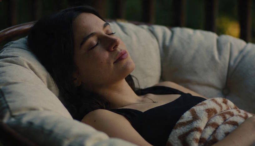 A woman person comfortably reclined in a soft chair with eyes closed under hypnosis in Dayton with peaceful facial expression