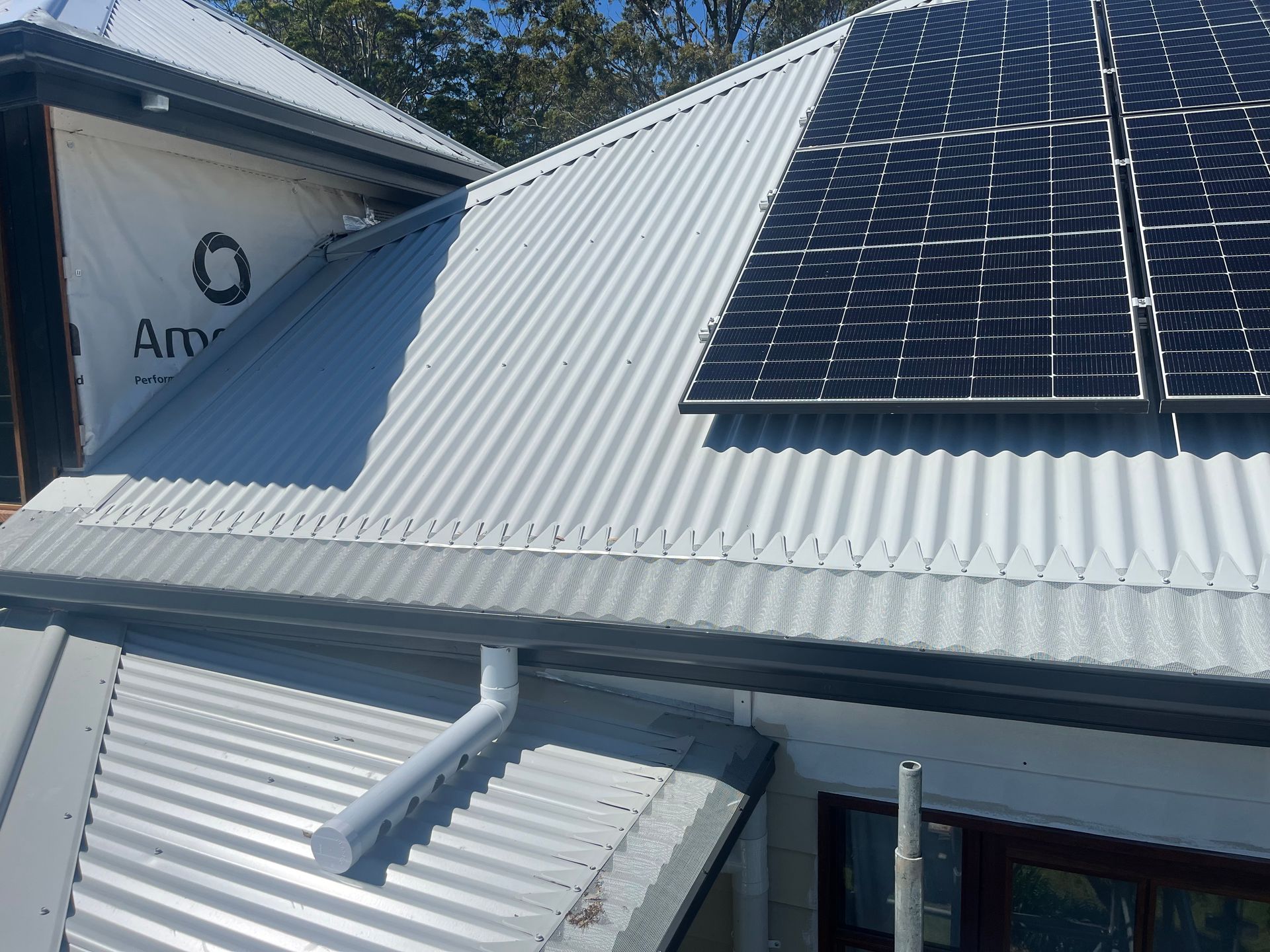 A Grey Gutter on the Side of a House With Solar Panels — Metal Roofing by Matt Dwyer in Gerringong, NSW