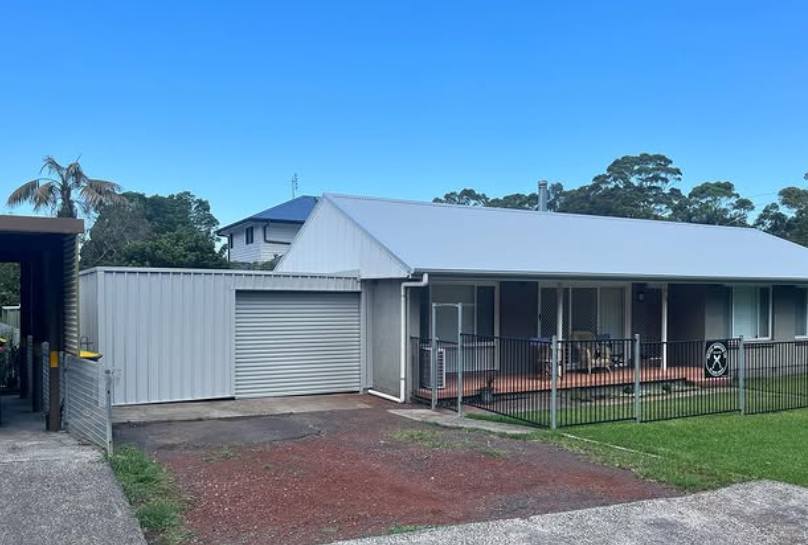 A White House With a Gray Roof and Blue Sky in the Background — Metal Roofing by Matt Dwyer in Gerringong, NSW