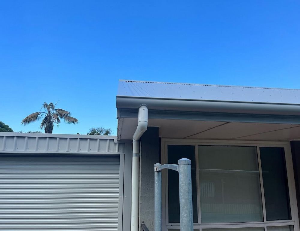 A House With a Garage Door and a Palm Tree in the Background — Metal Roofing by Matt Dwyer in Gerringong, NSW