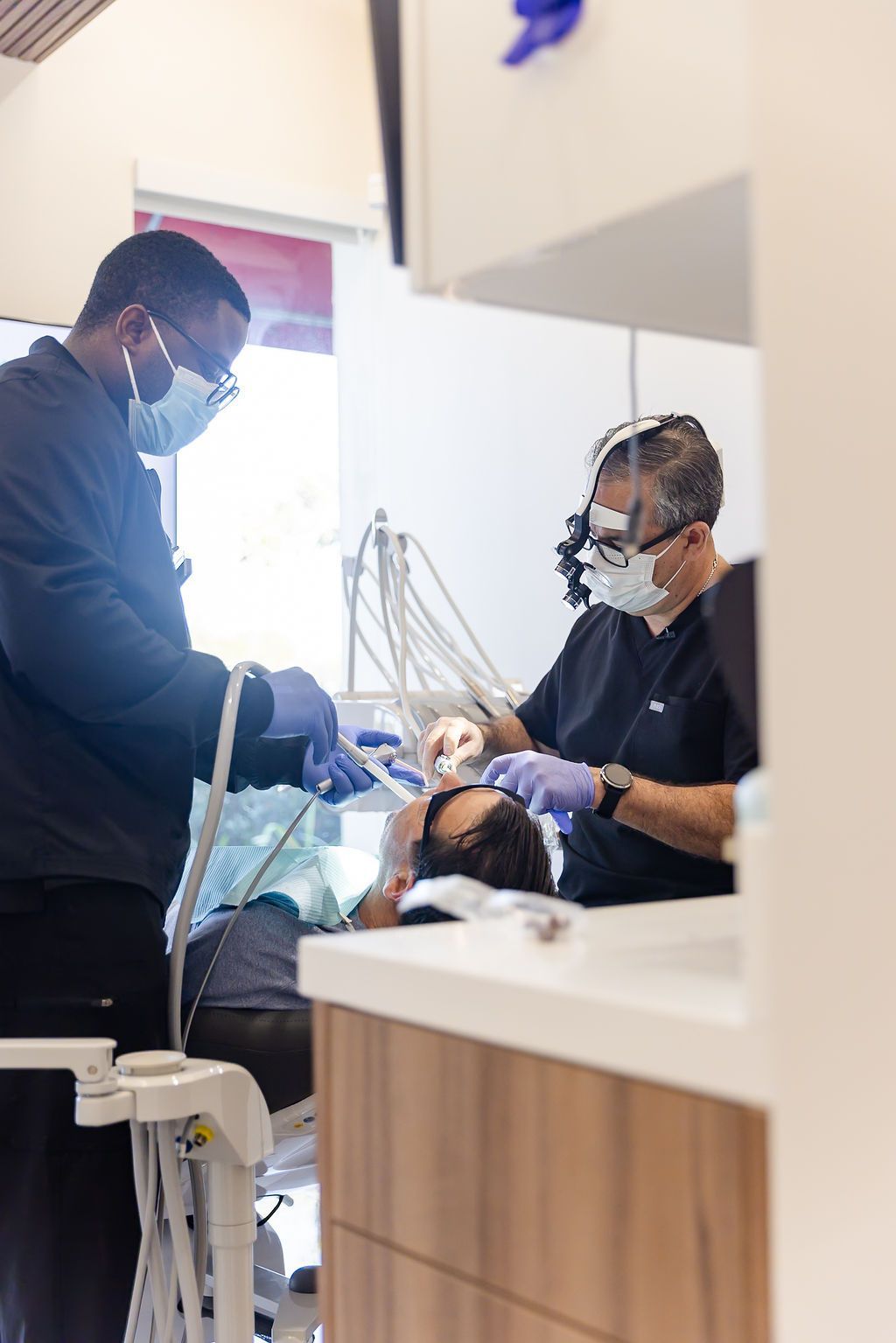 Dentist and assistant treating a patient in a dental clinic