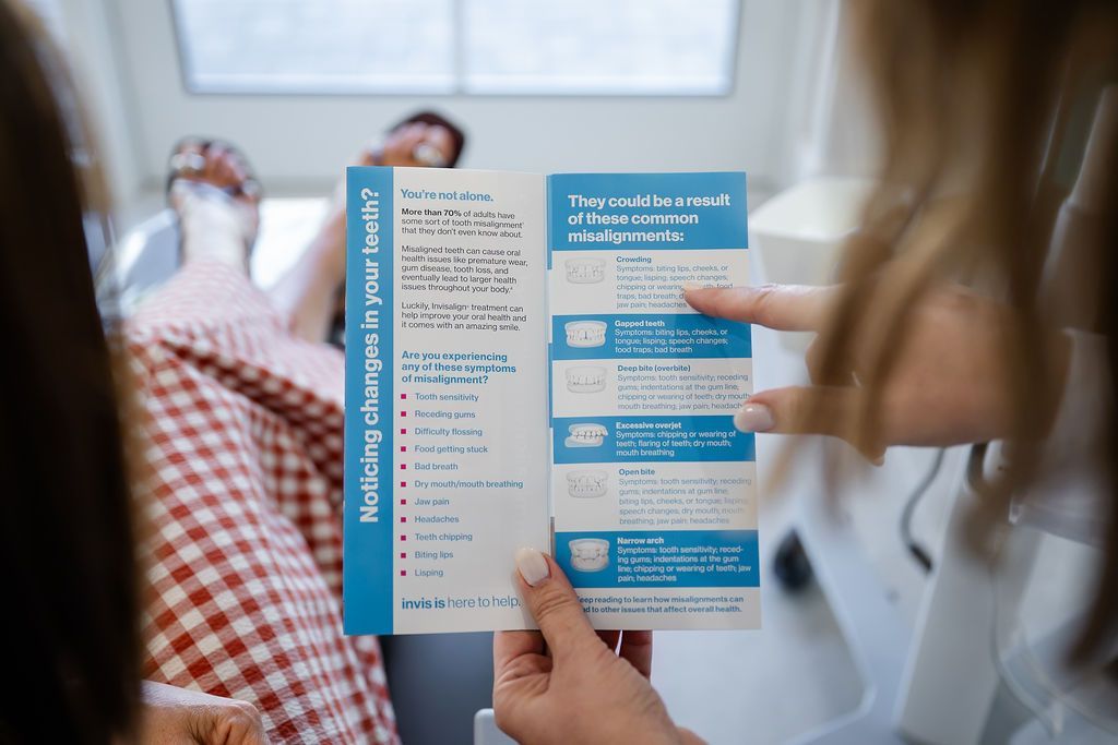 Patient reading an Invisalign information card about crooked and crowded teeth