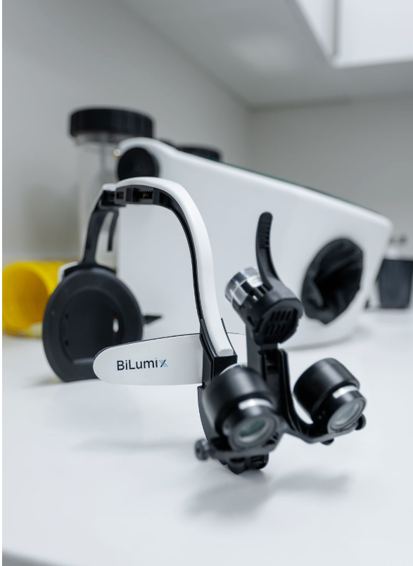 Dental magnifying loupes with an attached headlight on a clinic counter