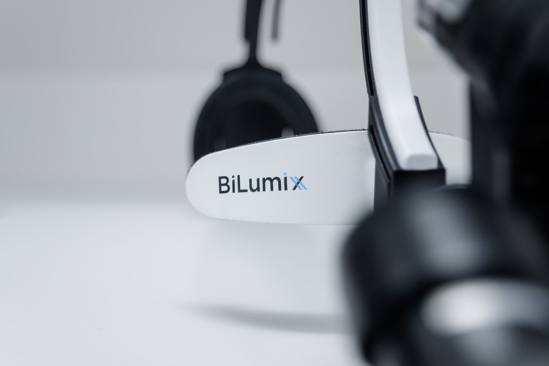 BiLumix headset on a table, close-up in a soft gray workspace setting