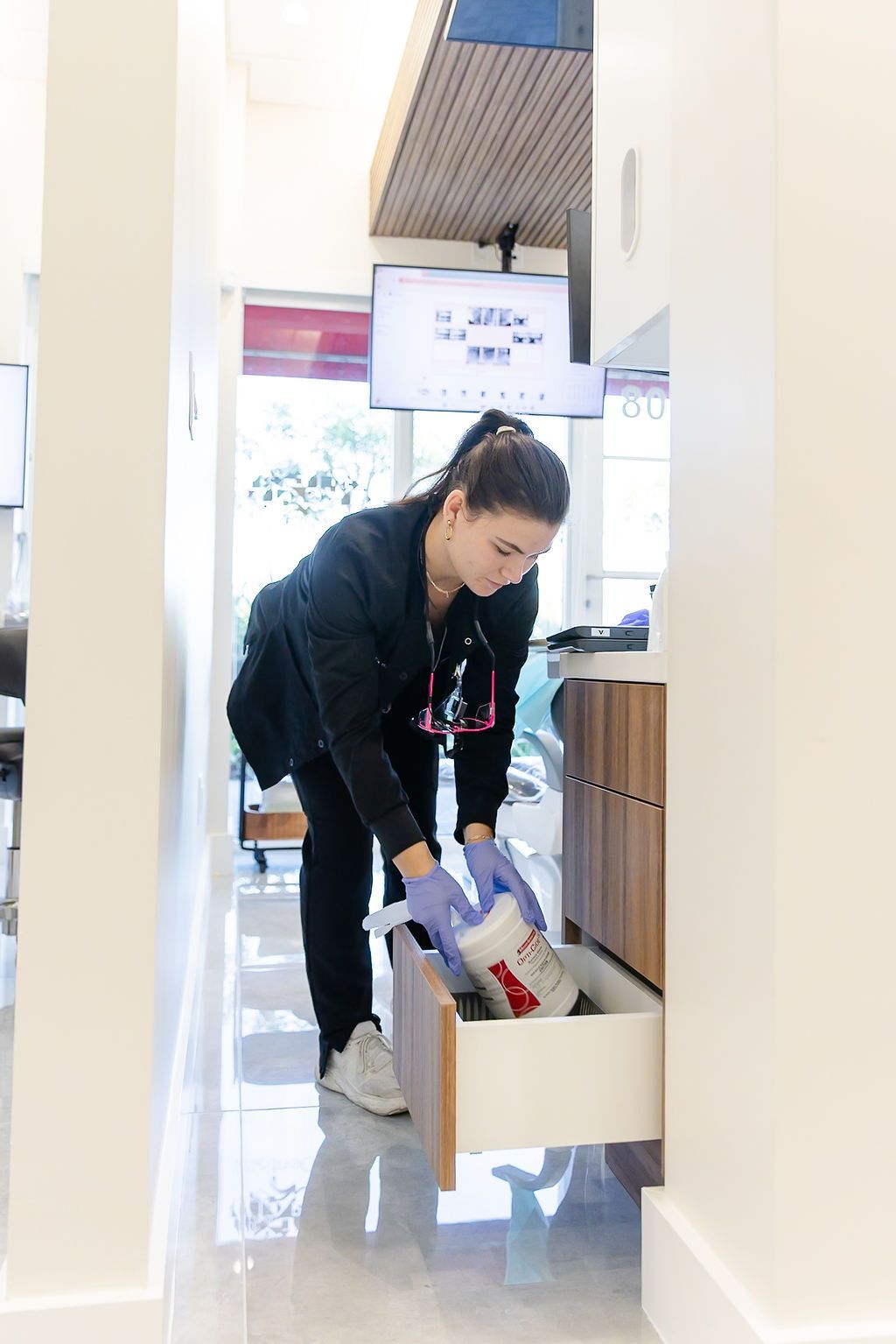 Team member restocking supplies in a GEN2 Dentistry treatment room
