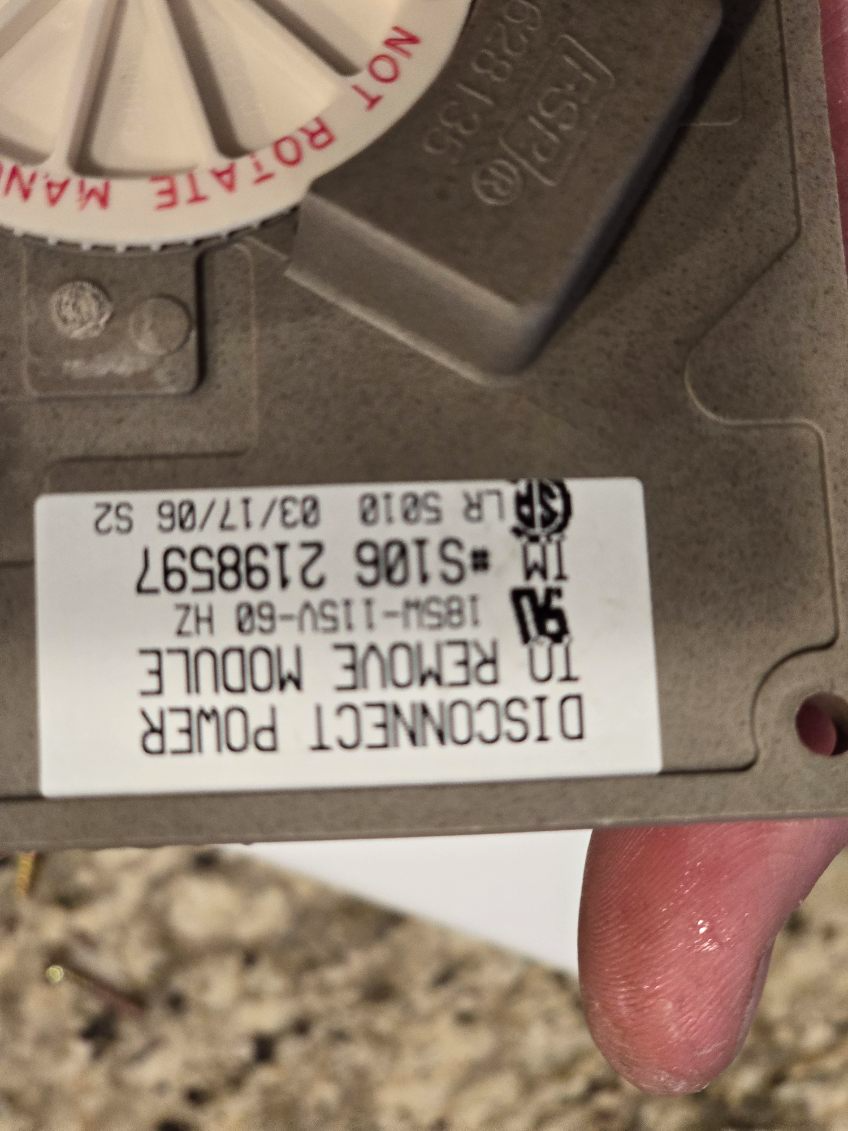 Close-up of a motor module with a sticker detailing power disconnect instructions and model information.
