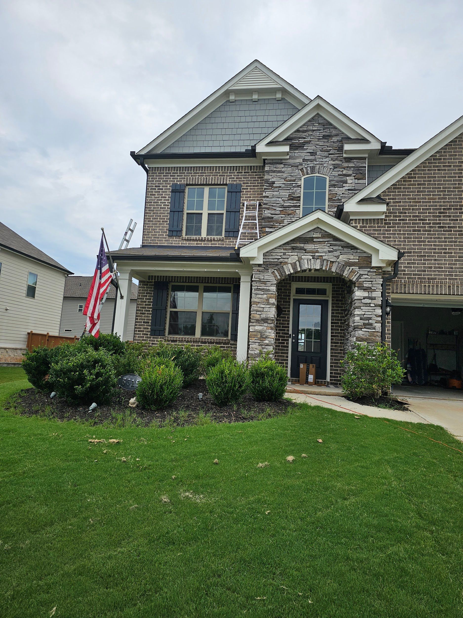 A large brick house with a large lawn in front of it.