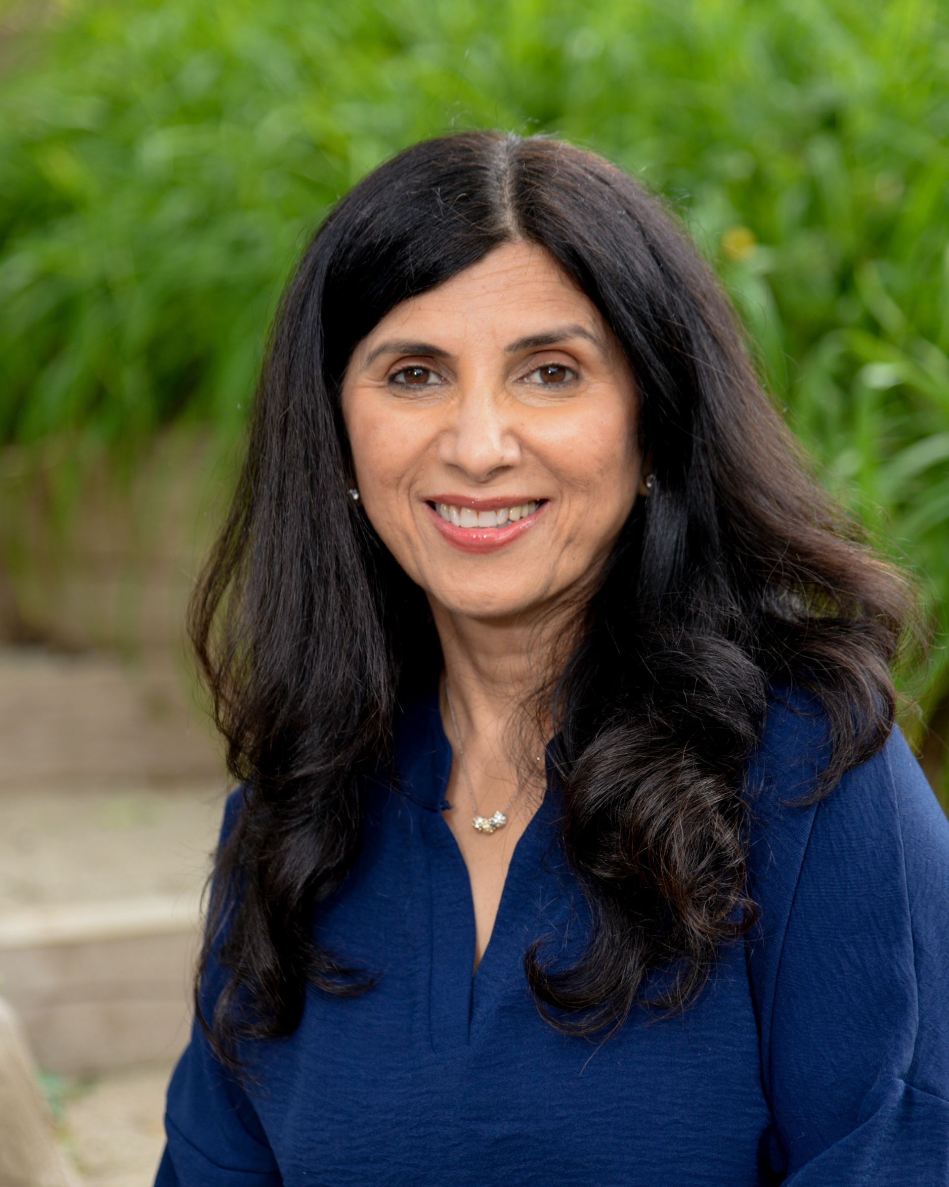 A woman in a plaid shirt is smiling in a circle.