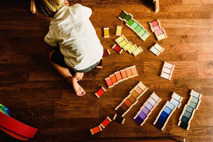 A child is playing with wooden blocks on the floor.