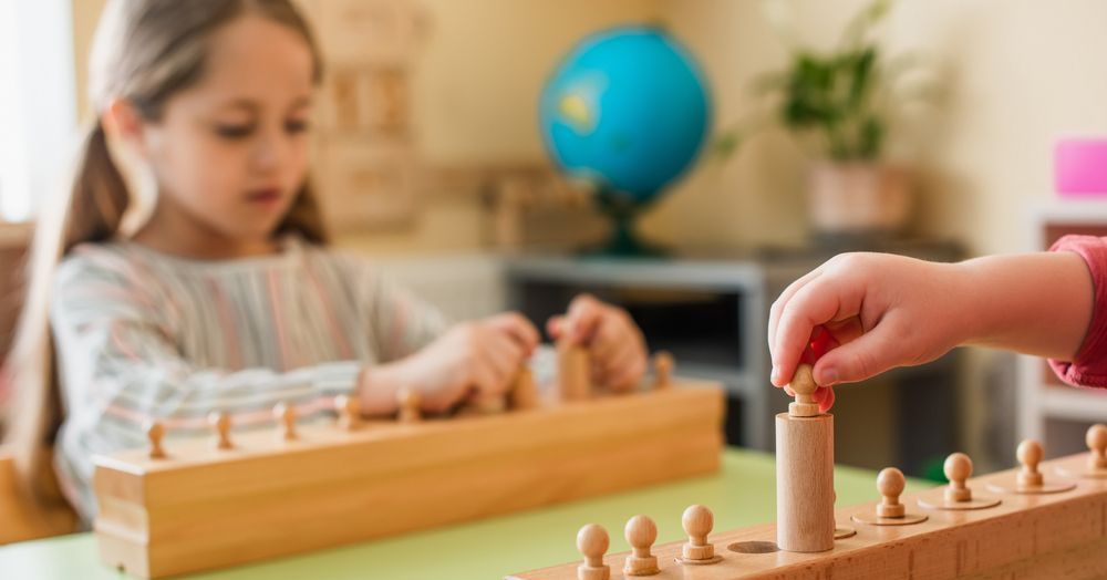 Children using a wooden Montessori counting toy in a classroom, with a blue globe in the background