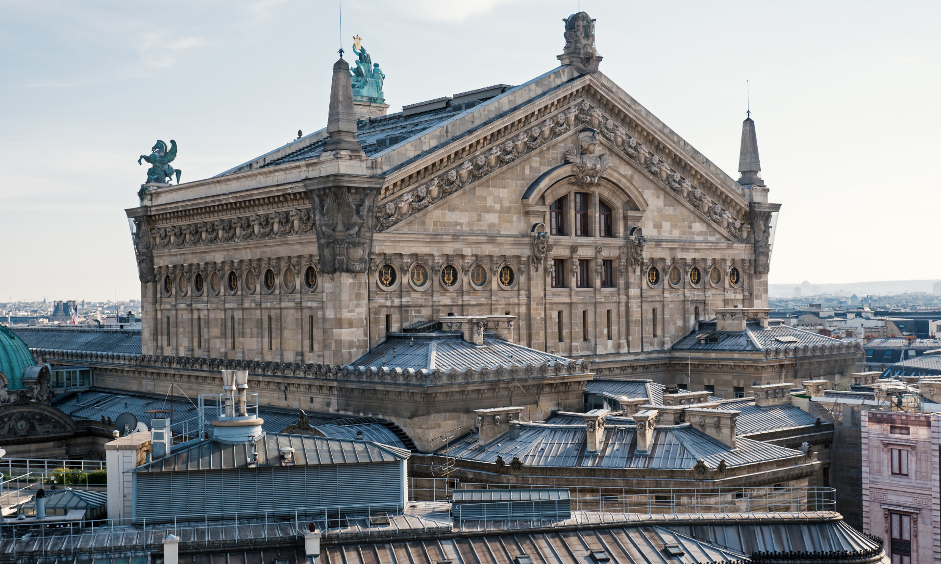 Paris'teki Opéra Garnier binasının dış cephesi, süslü taş mimarisi, çatıdan görünüm.