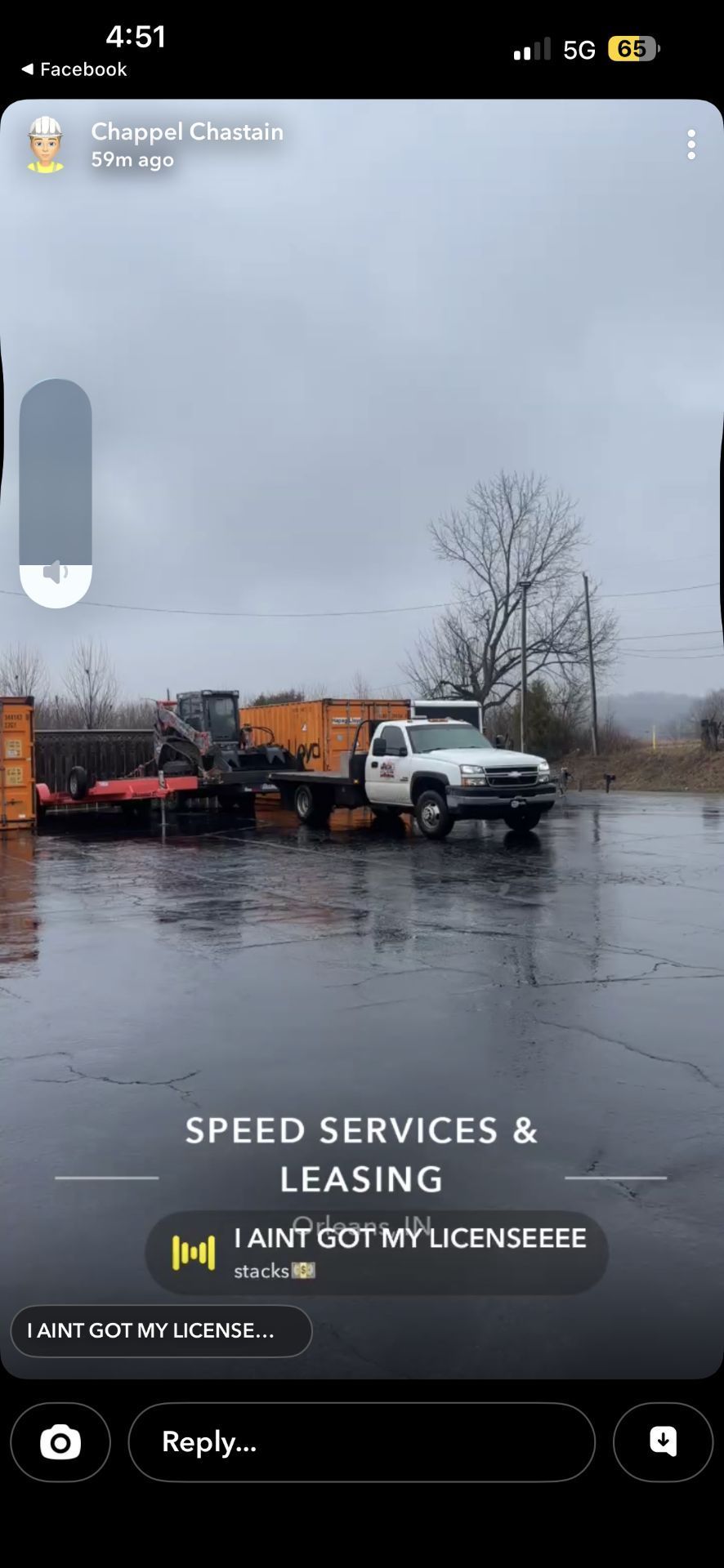 A white pickup truck pulling a trailer with a yellow excavator parked on an asphalt lot under a cloudy sky.