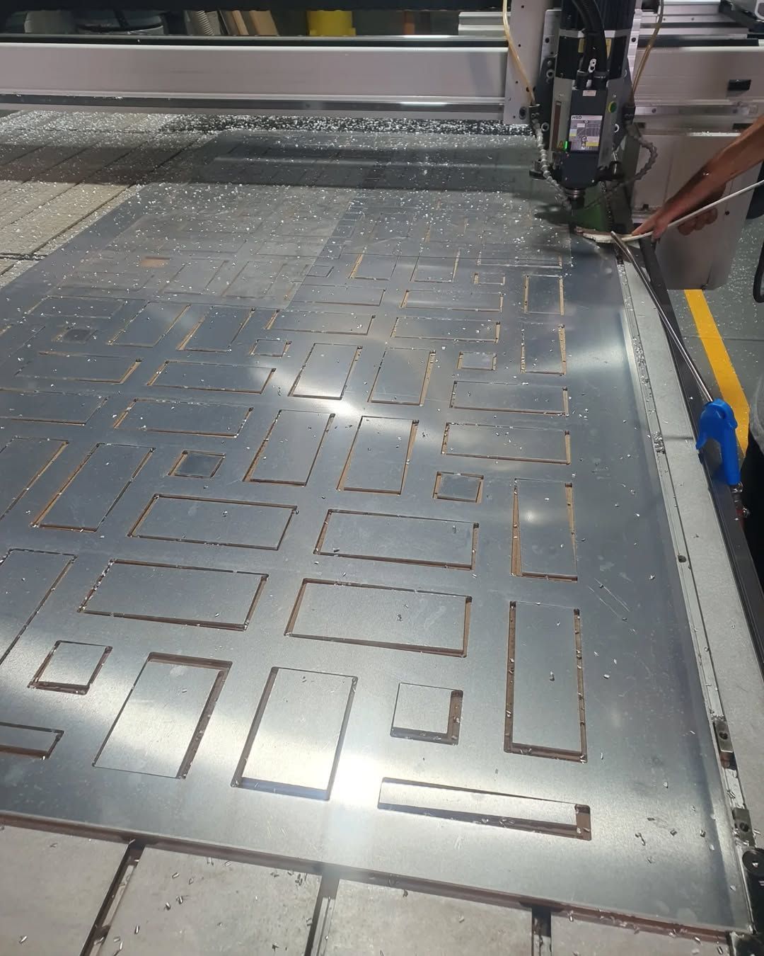 A Machine is Cutting a Piece of Metal in a Factory — Coastal Plastics In Tweed Heads South, NSW