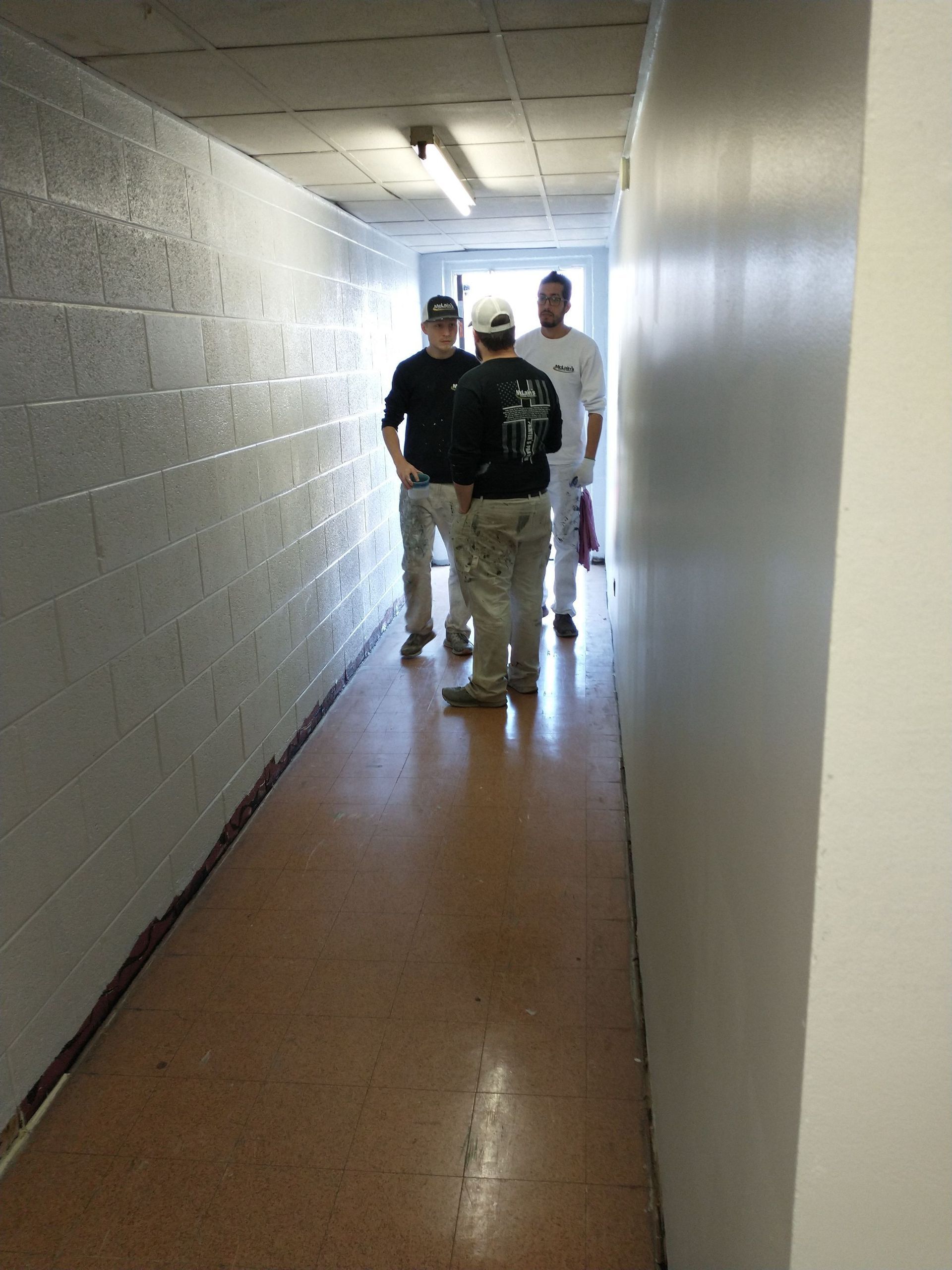 A group of men are walking down a hallway