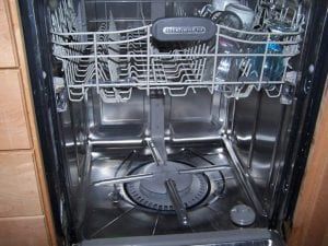 The inside of a dishwasher is empty and ready to be used.