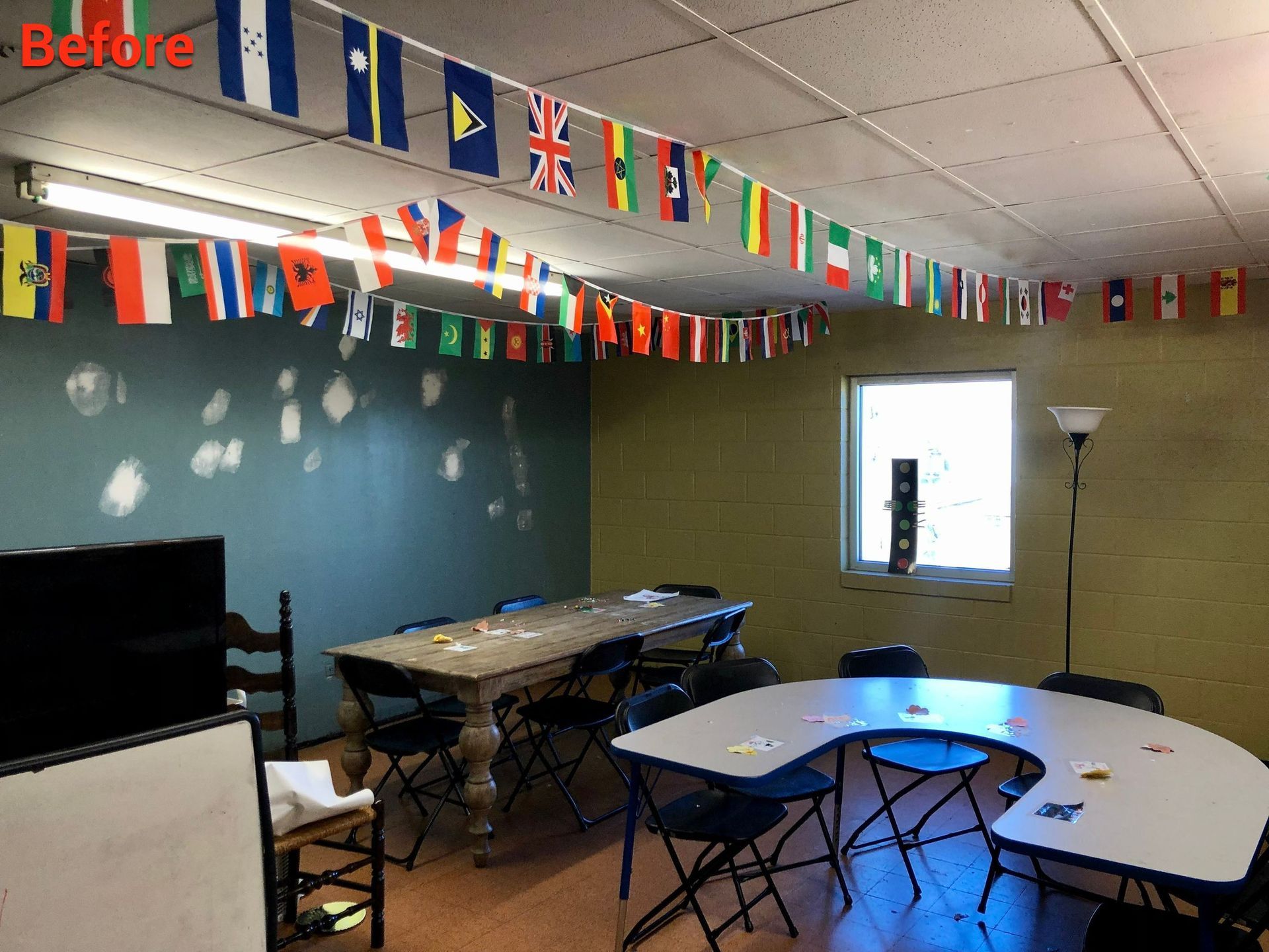 A room with tables and chairs and flags hanging from the ceiling