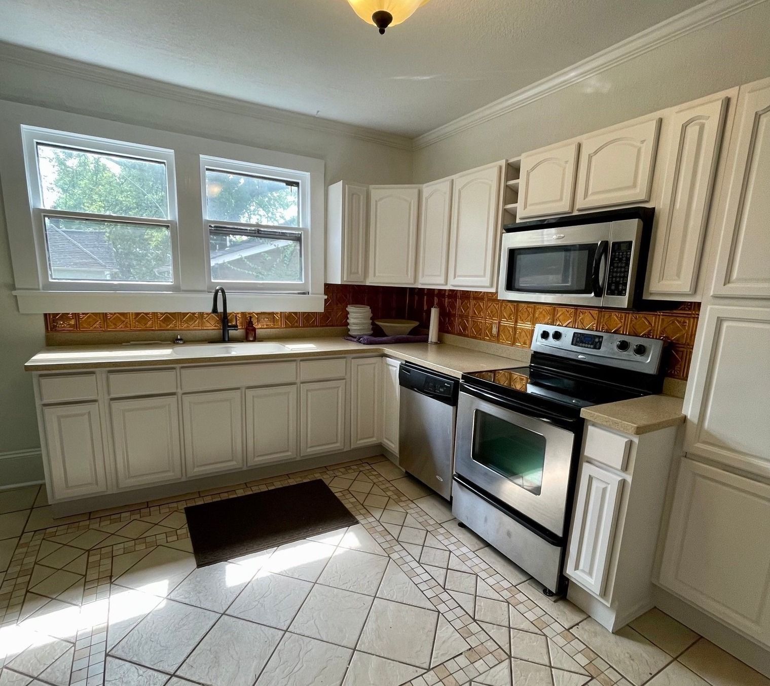 A kitchen with white cabinets and stainless steel appliances