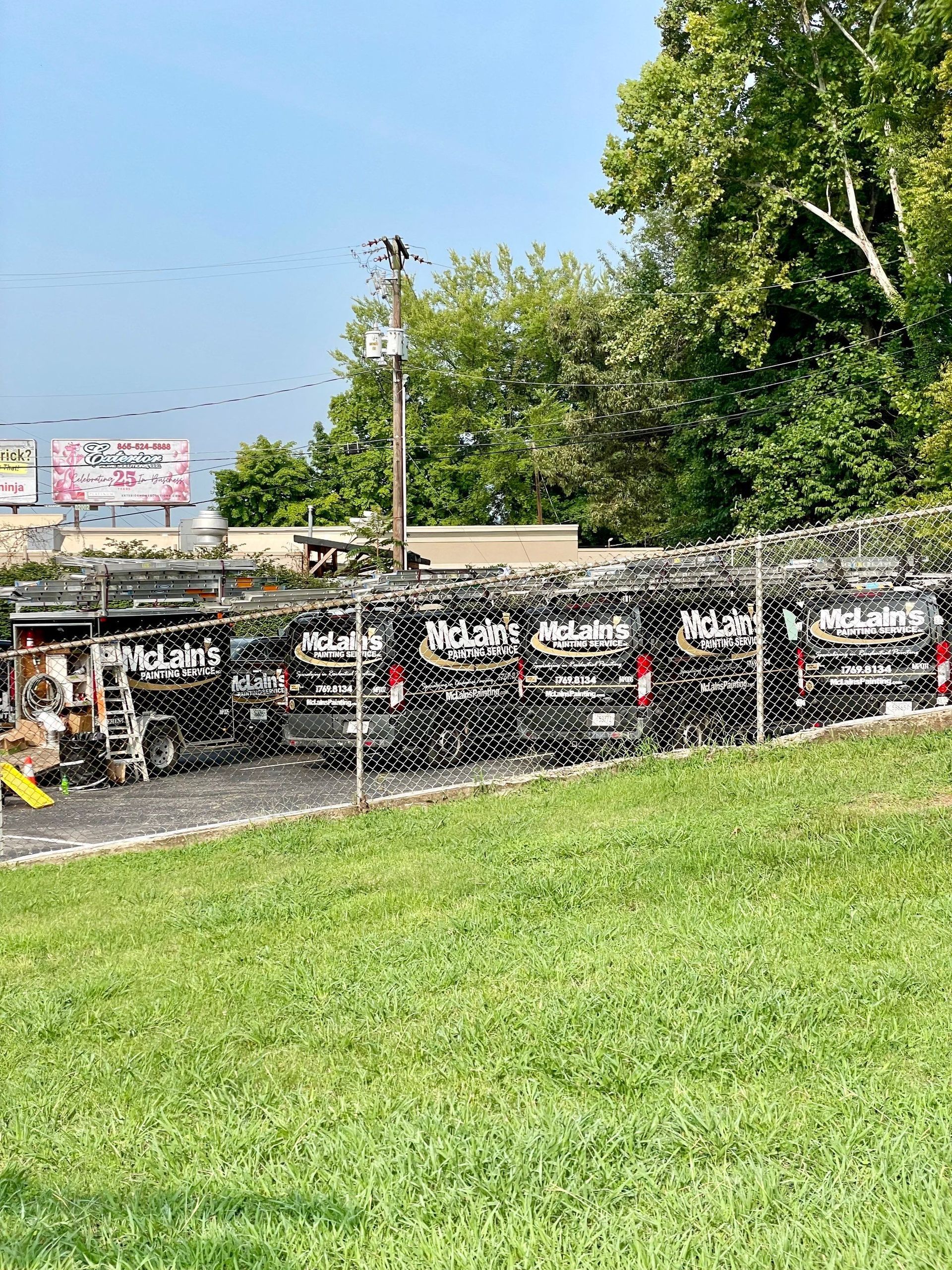 A row of cars are parked in a grassy field.