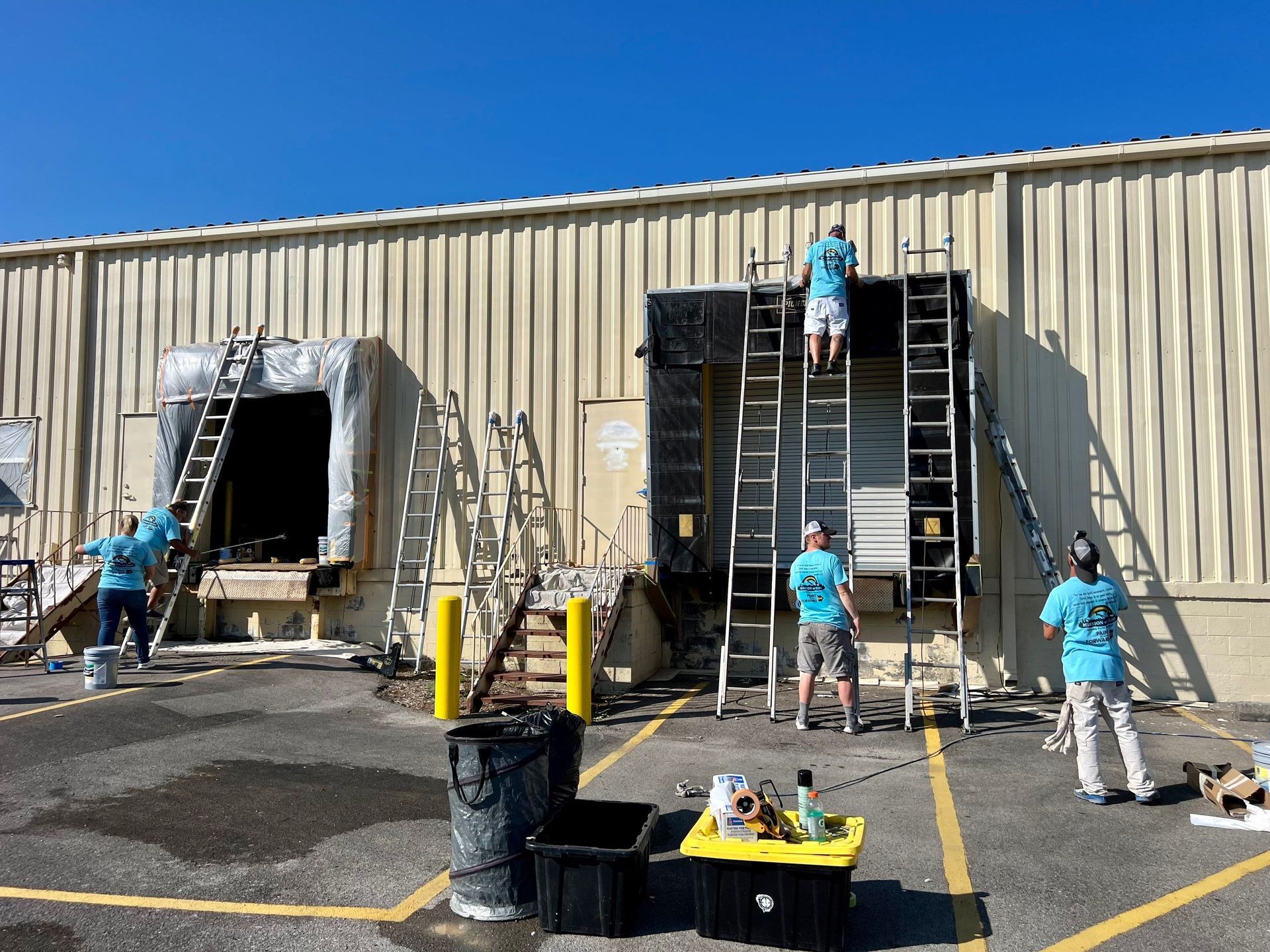 A group of people are painting the side of a building.