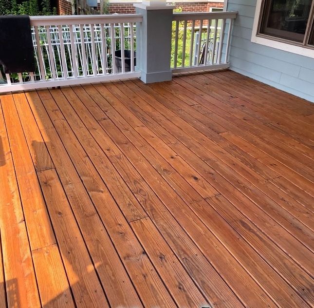 A wooden deck with a white railing and a window.
