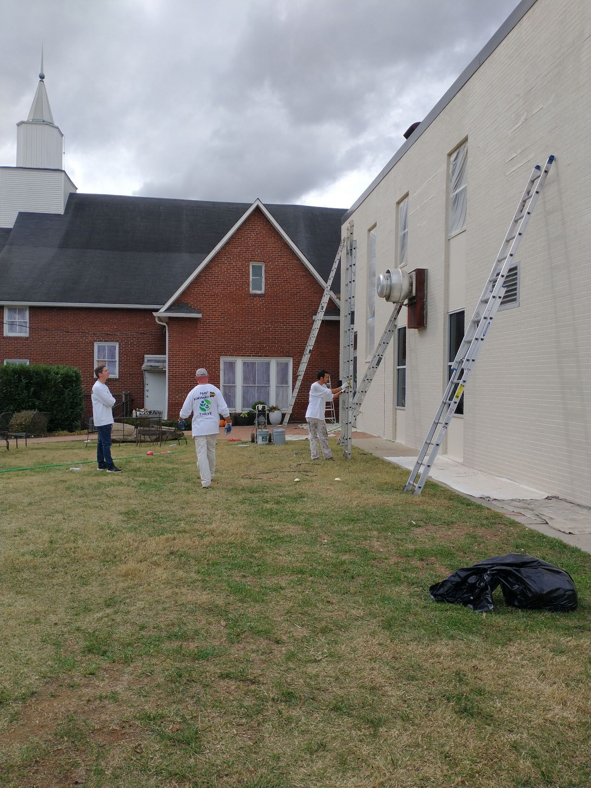 A group of people are painting the side of a building.