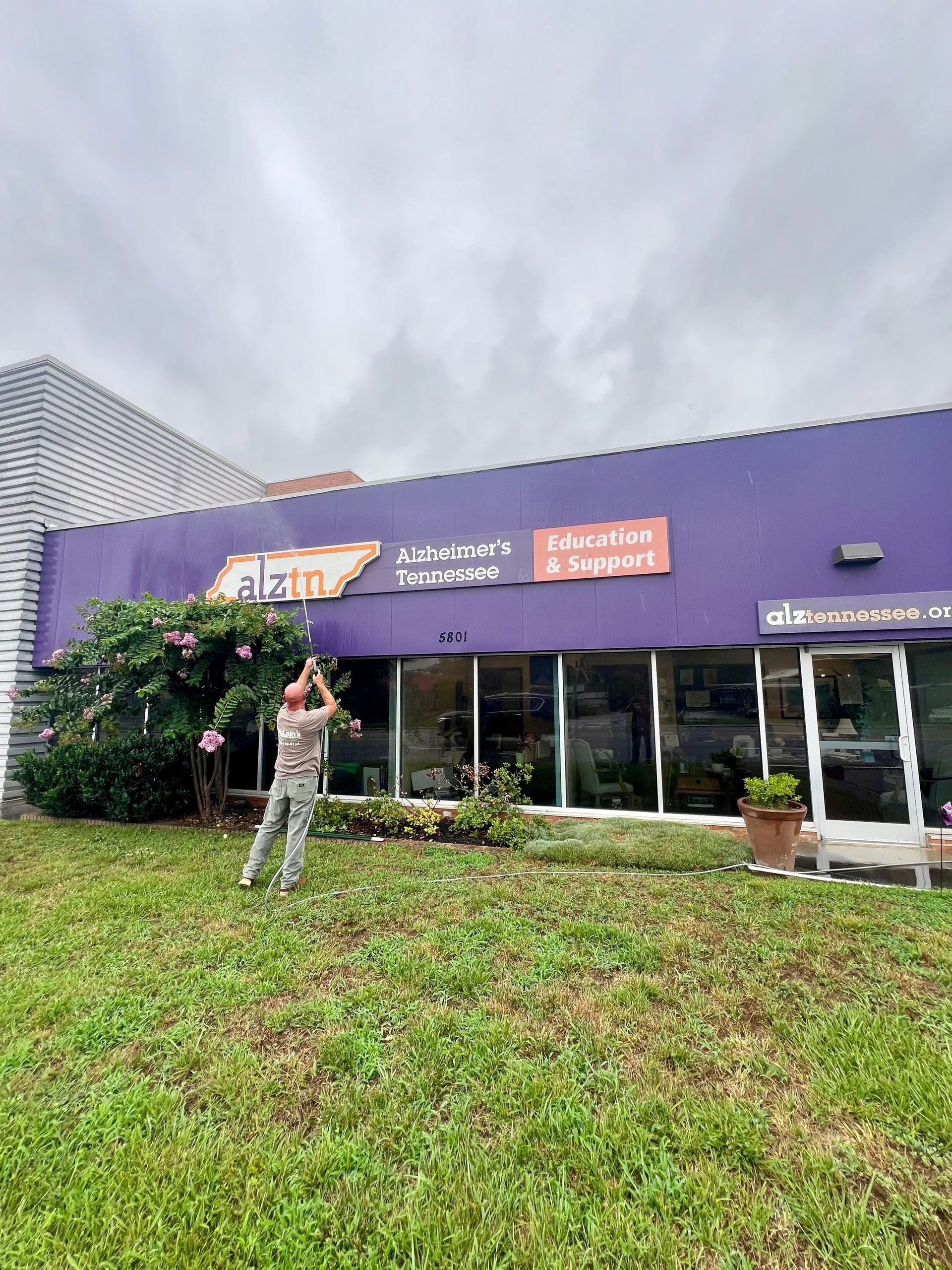 A man is standing in front of a purple building.