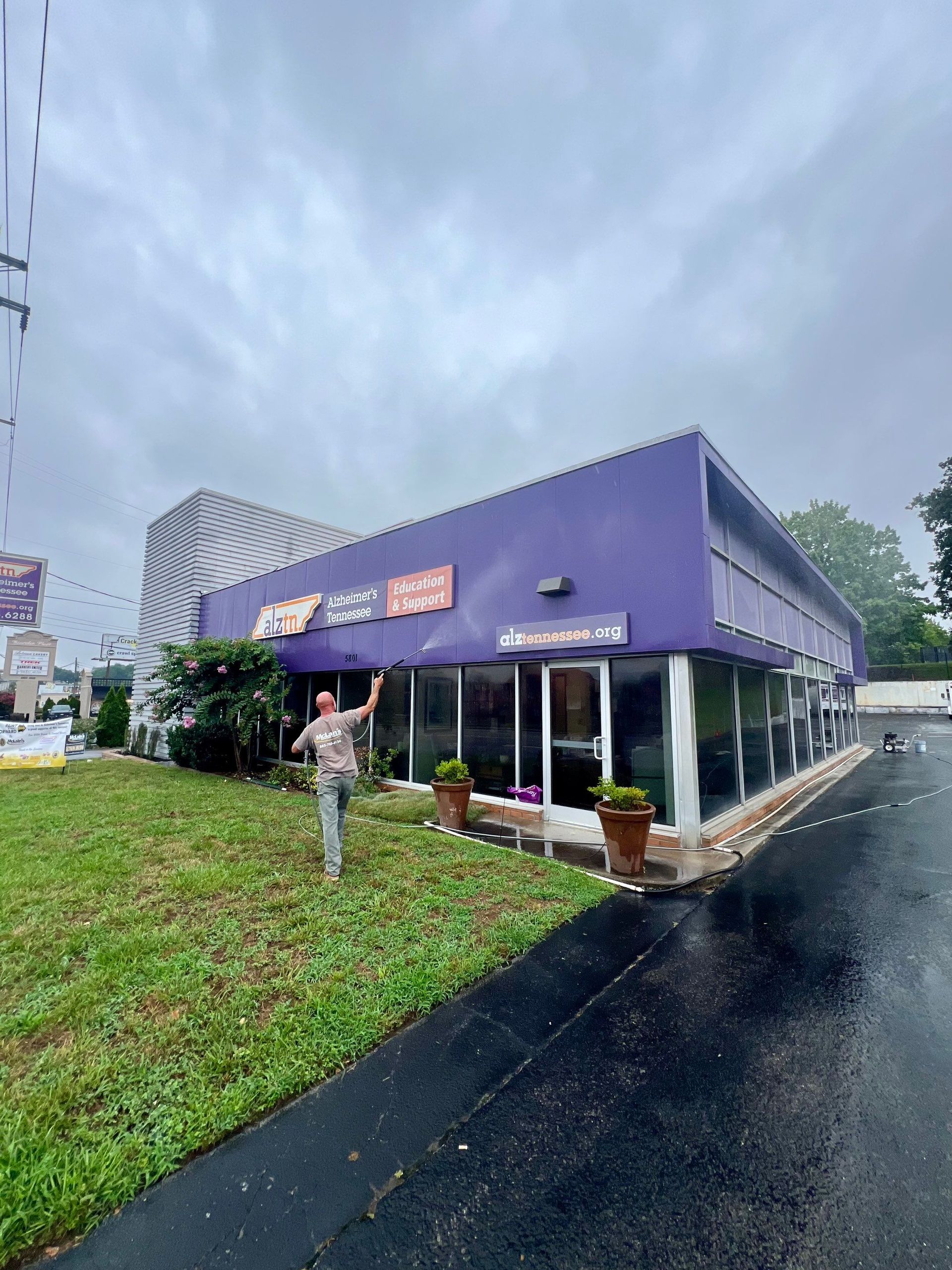 A man is standing in front of a purple building.