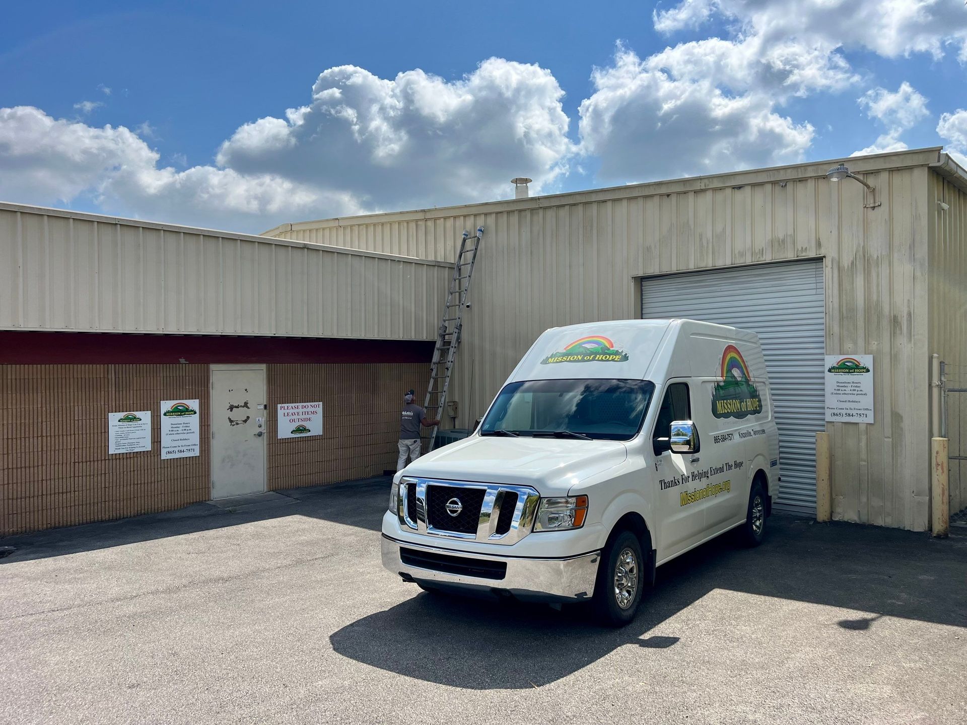 A white van is parked in front of a building.