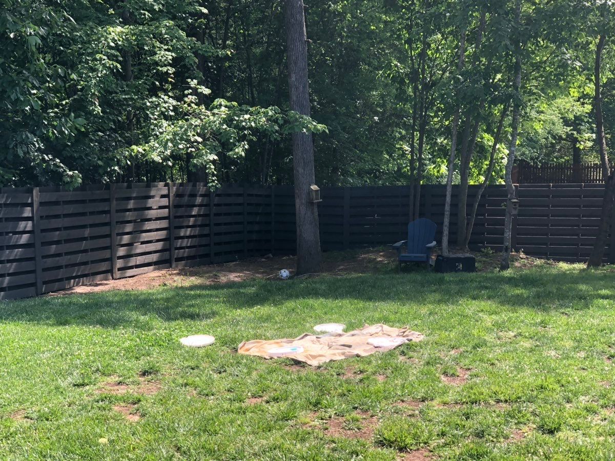A backyard with a wooden fence and a swing.