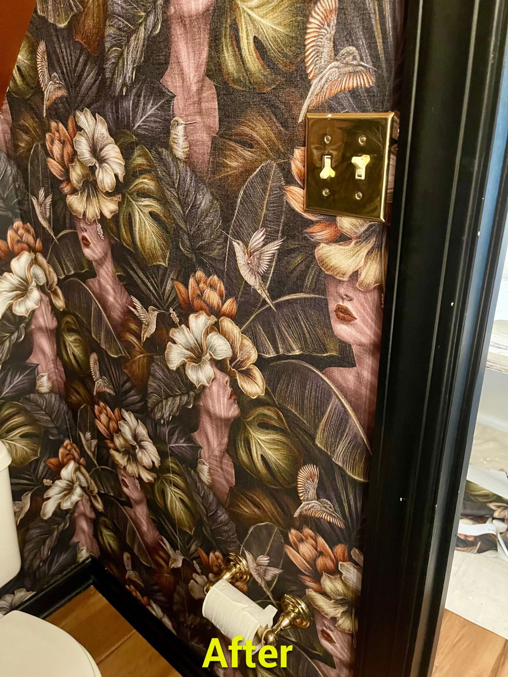 A bathroom with a floral wallpaper and a toilet.