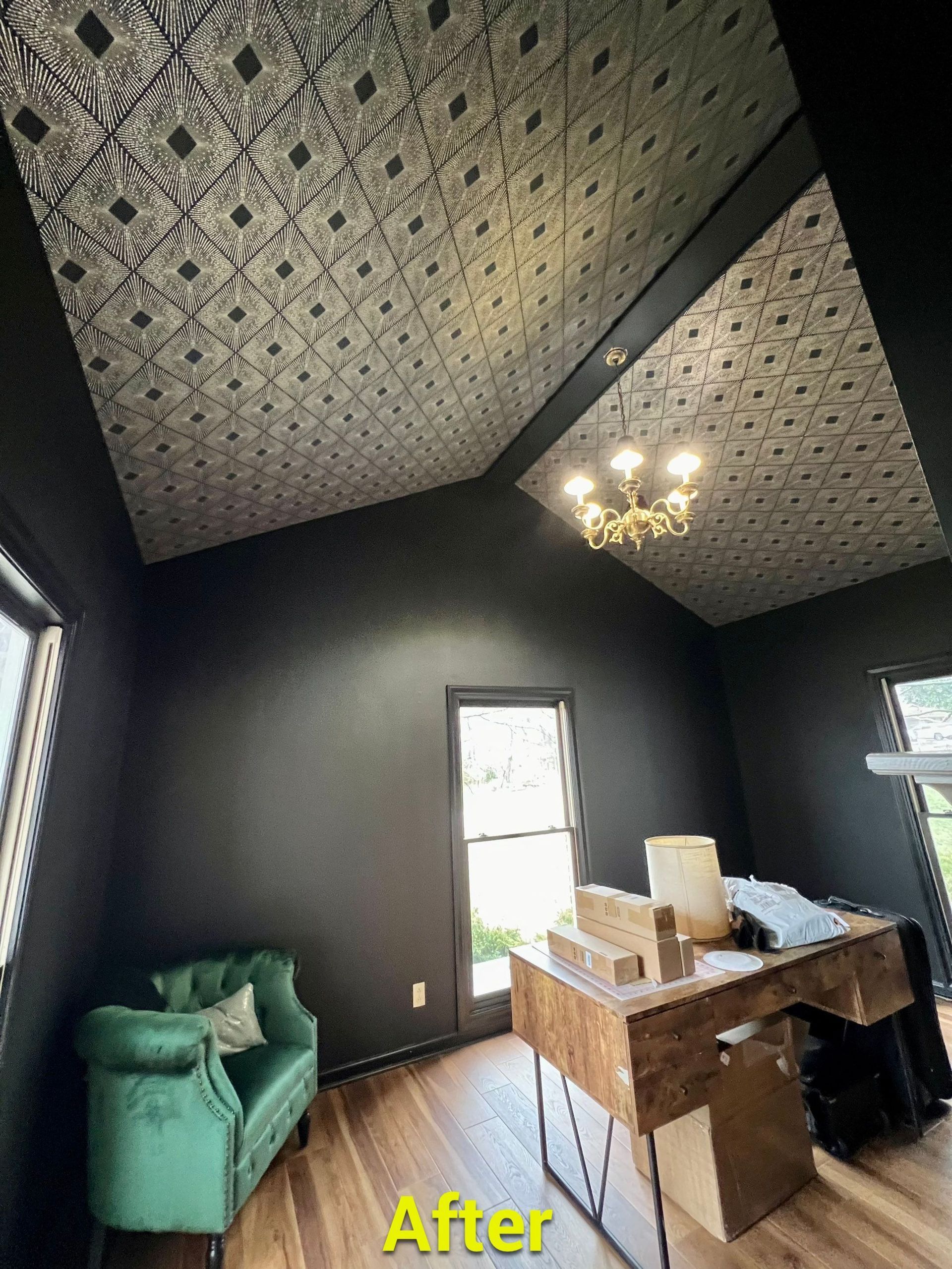 A room with a desk , chair , and mirror on the ceiling.