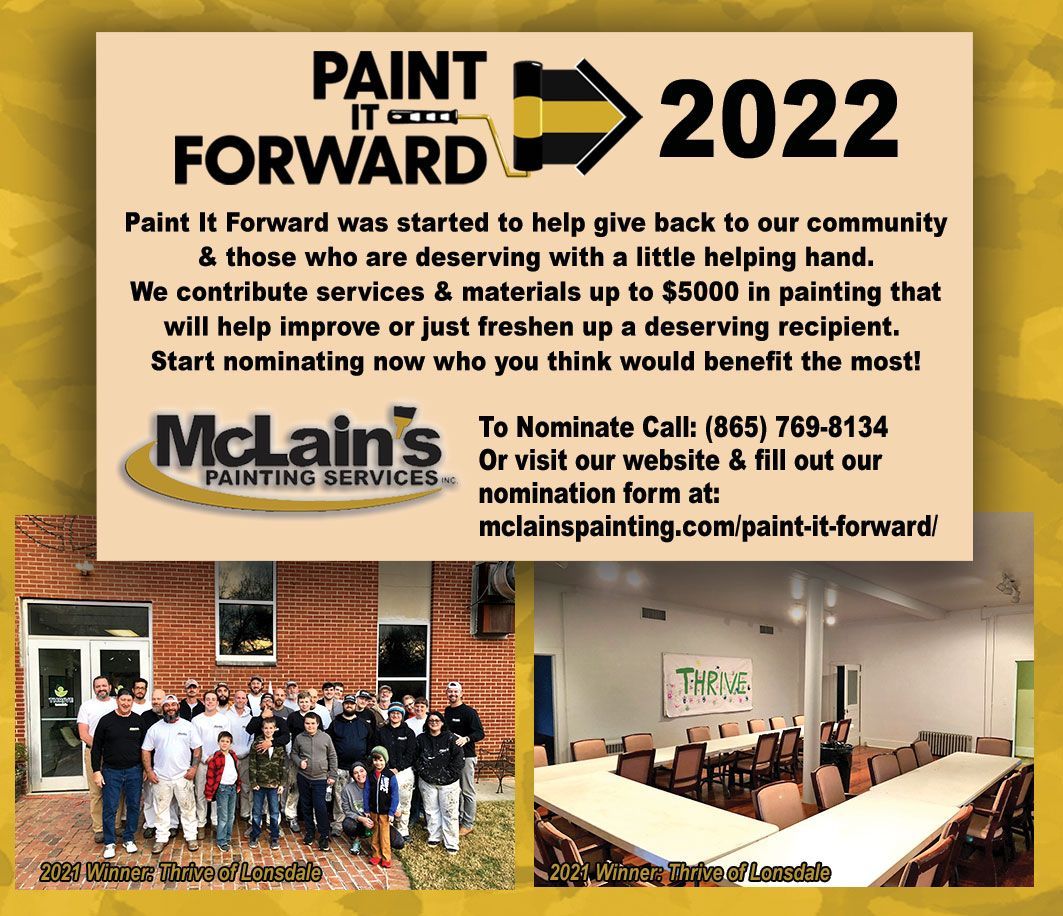 A group of people are standing in front of a building with a sign that says paint forward 2022