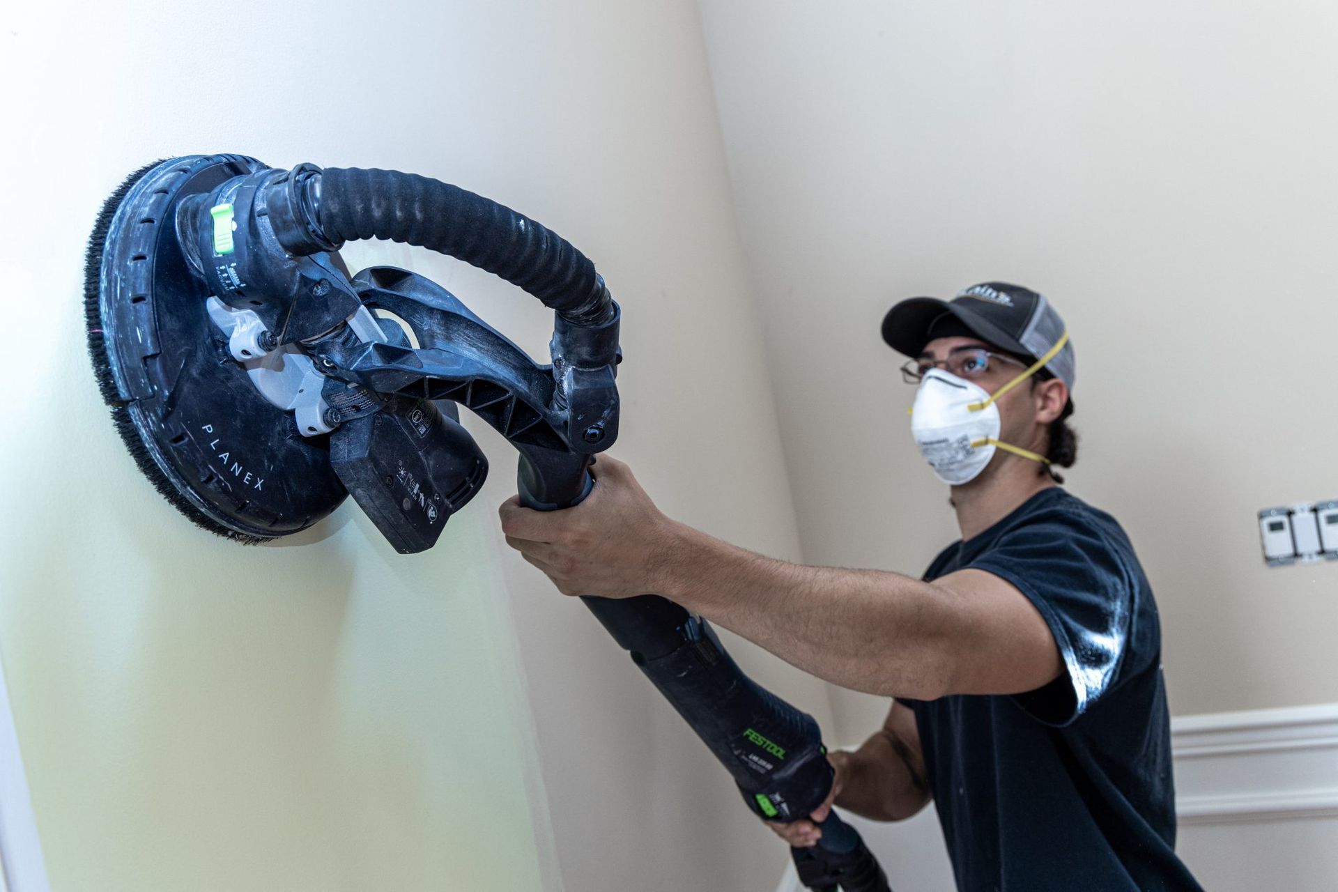 Mclains painting employee prepping wall for paint