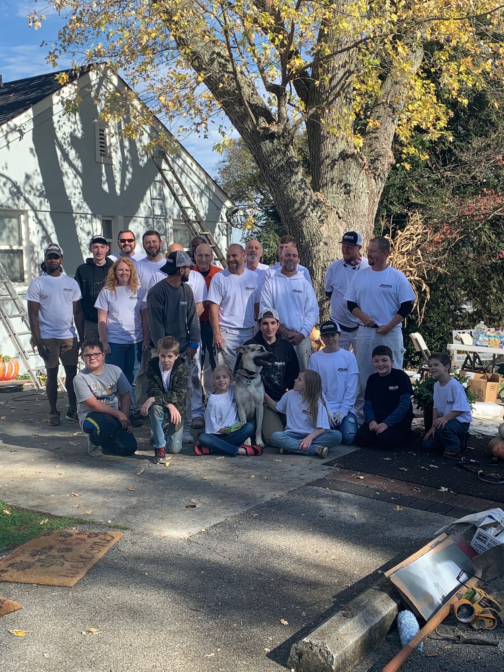 A group of people are posing for a picture in front of a house.