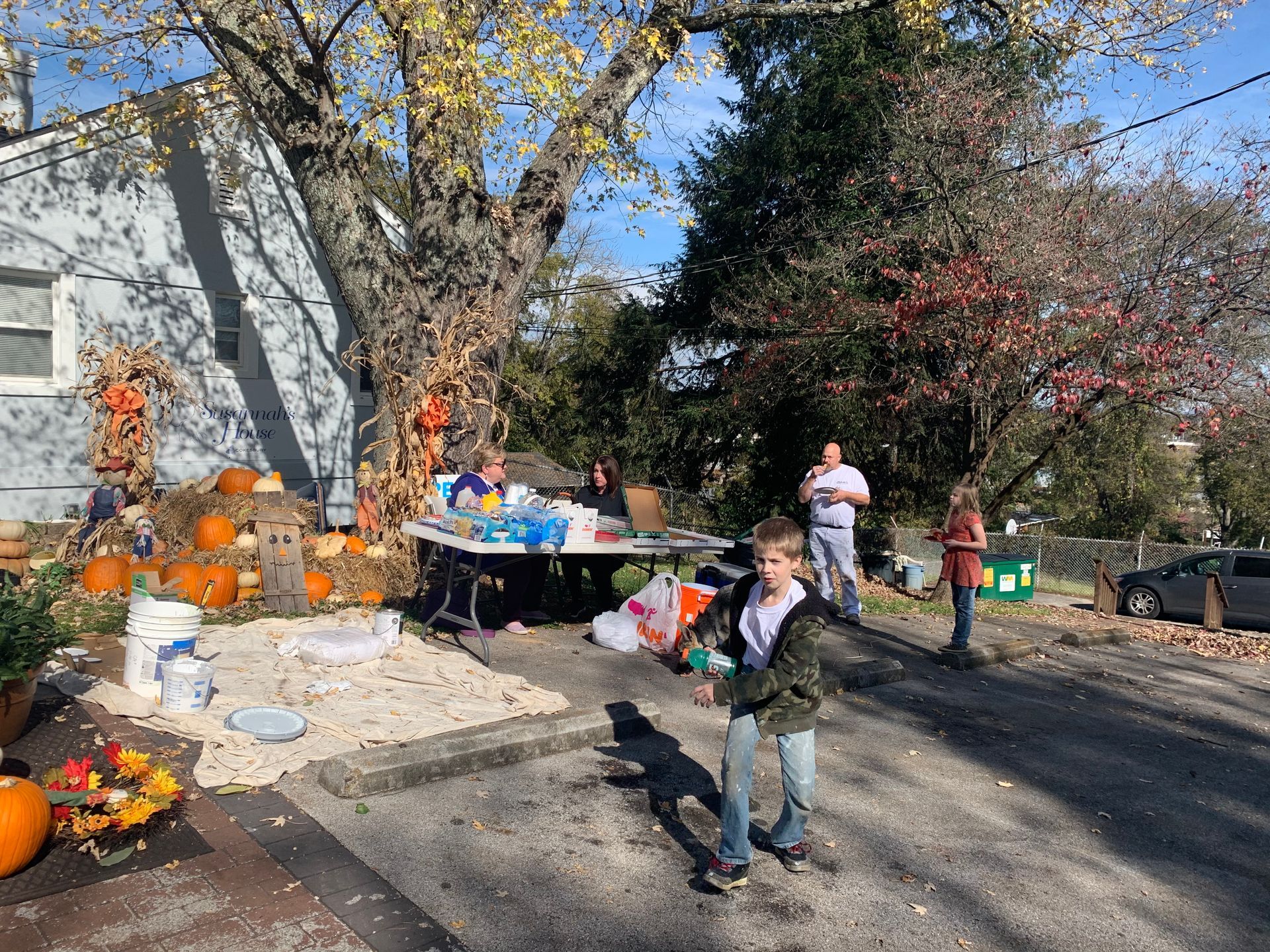 A young boy is standing in front of a house decorated for halloween.