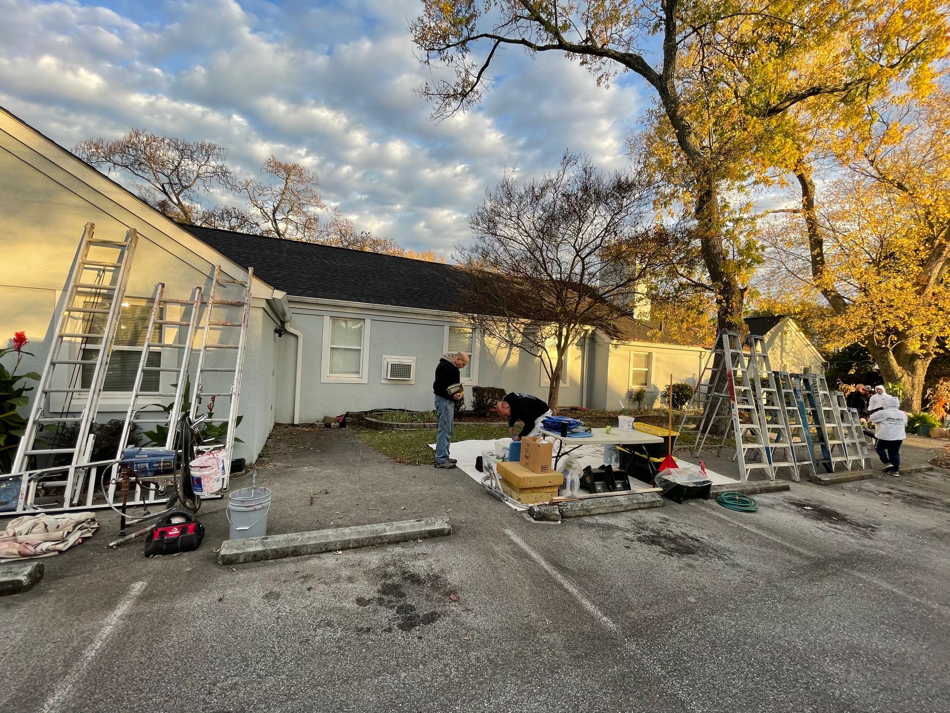 A group of people are working on a house in a parking lot.