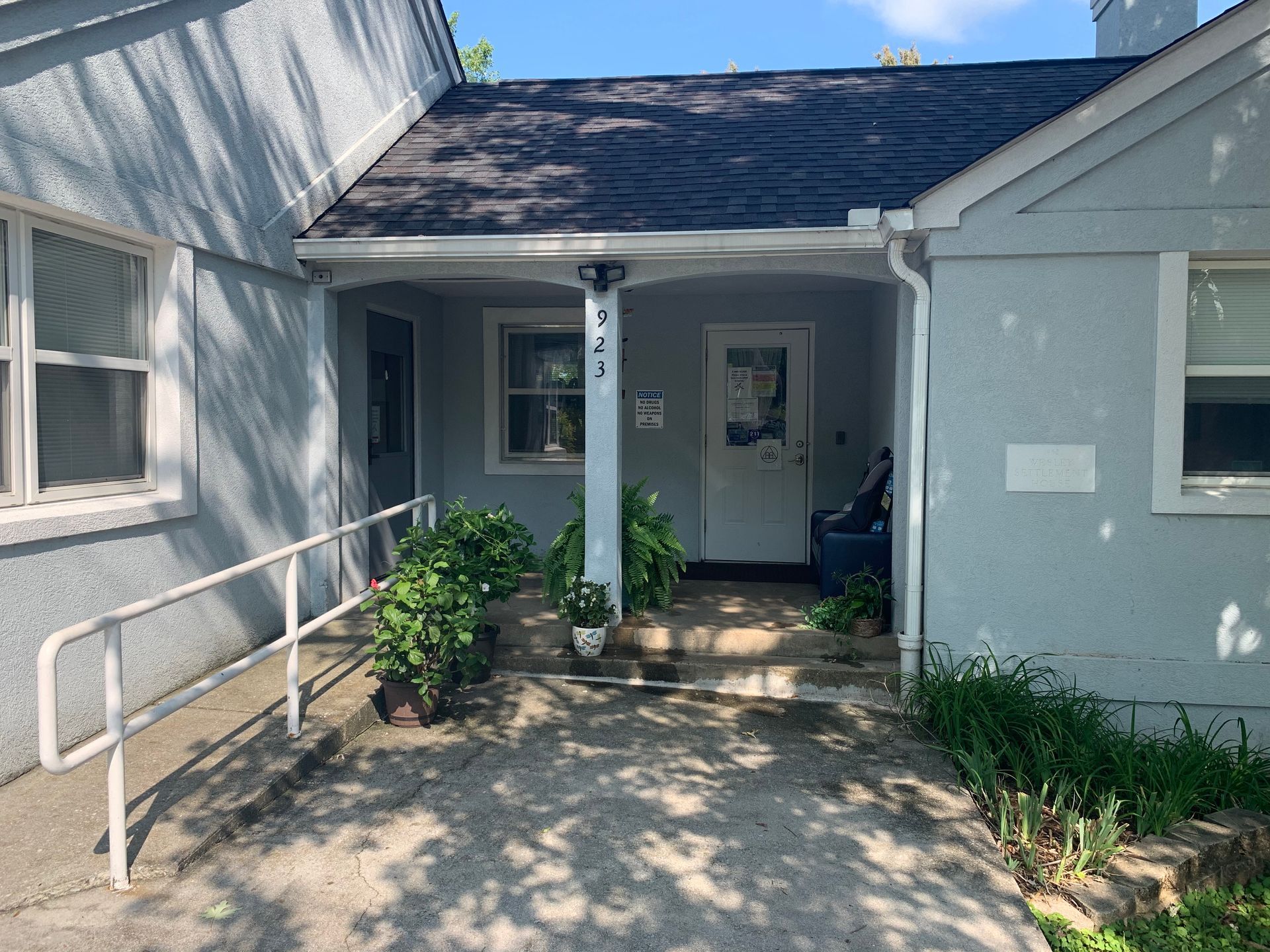 The front of a house with a handicap ramp and a porch.