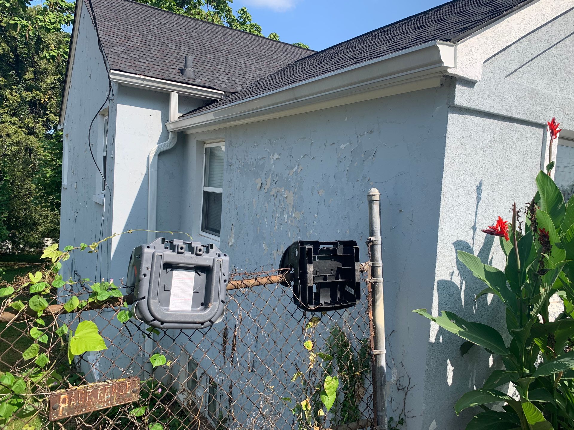 A blue house with a black box on the side of it.
